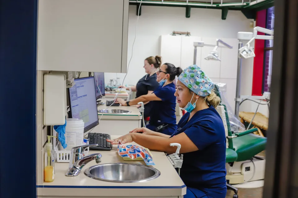 A hygienist at the sink in a treatment room