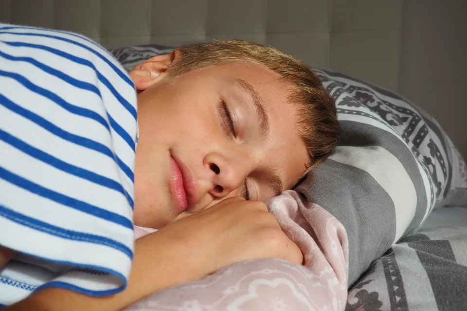 A young boy asleep in striped pyjamas