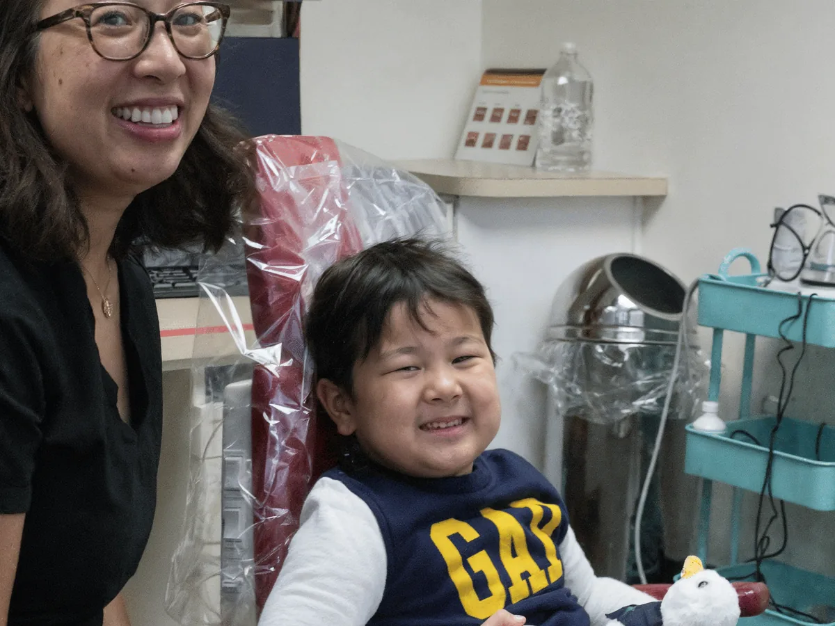 Dr. Tam Nguyen beside a smiling child