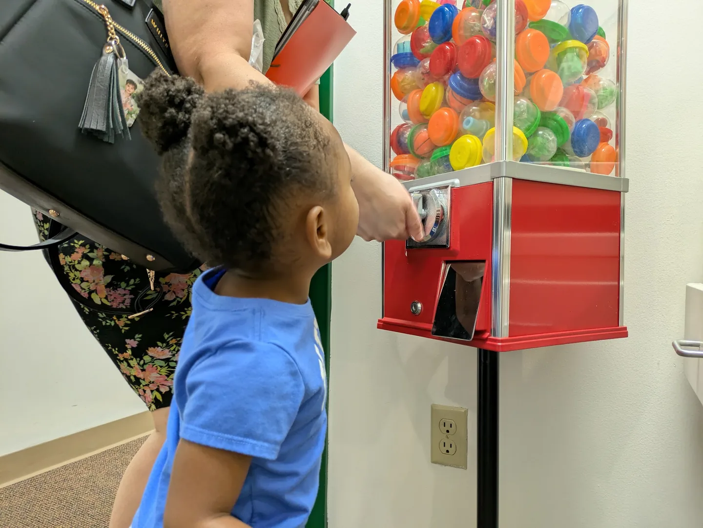 A toddler reaching for the gumball machine by the front desk