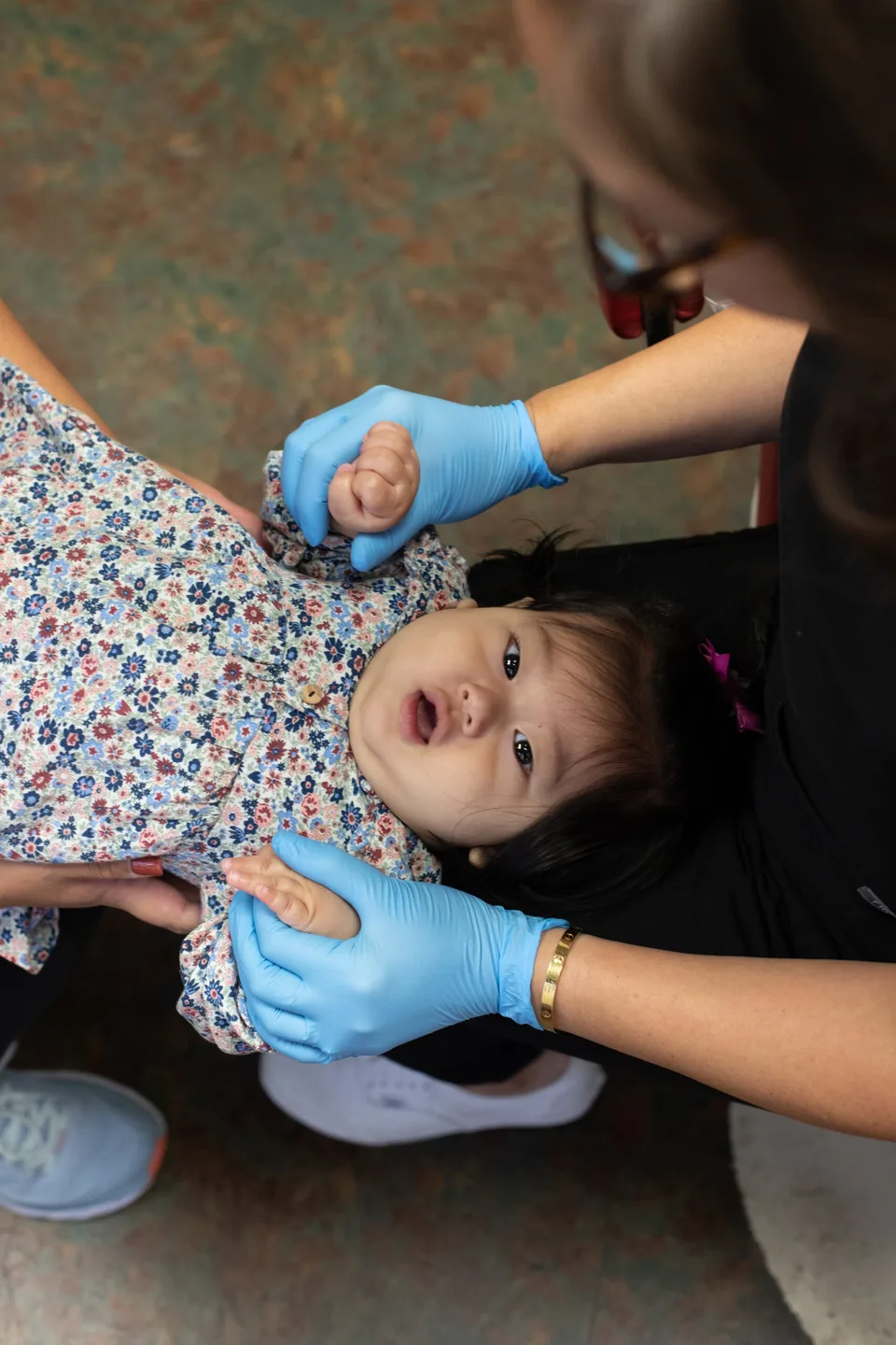 An infant on a parent's lap during a knee-to-knee exam at Mason Park Dental for Kids