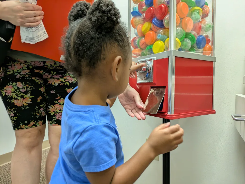 A toddler at the gumball machine by the front desk