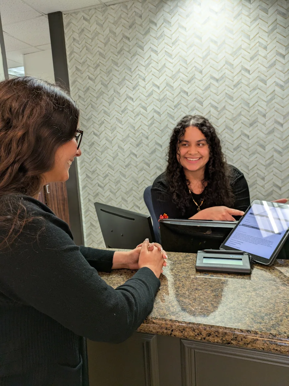 A patient at the front desk, with the receptionist