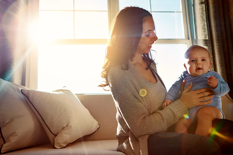 A parent holding a smiling baby